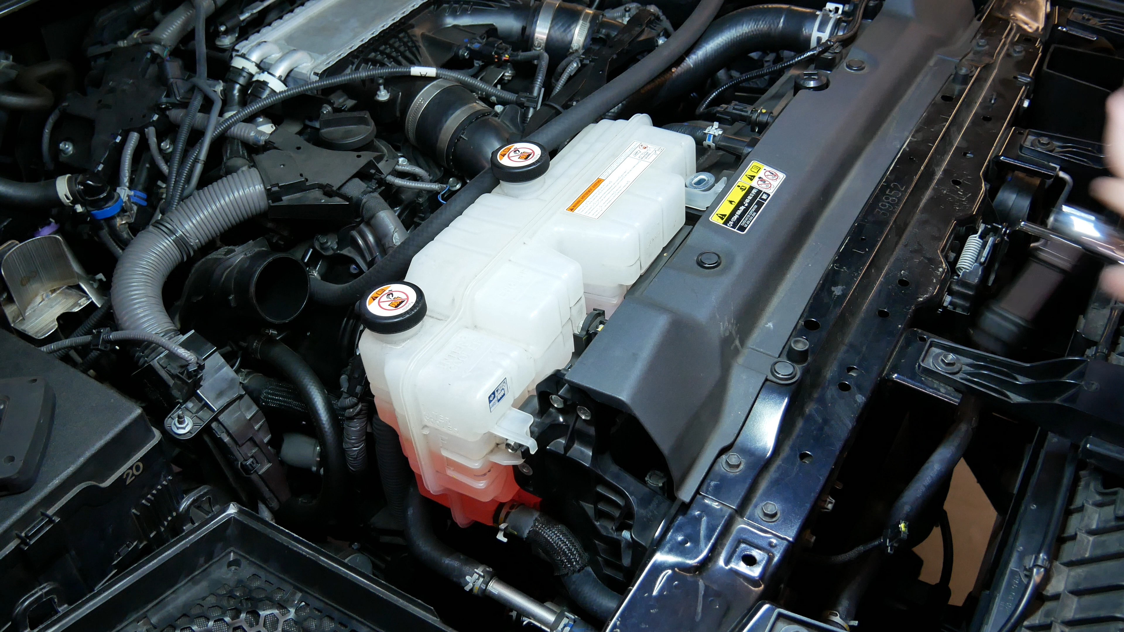 Toyota Tundra engine bay showing OEM radiator and intercooler reservoirs sharing the same wall.